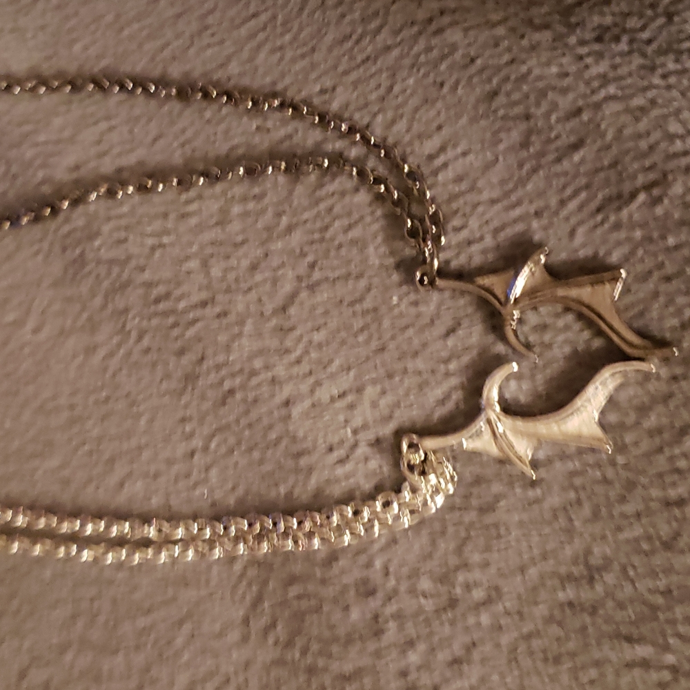 Bat wings forming heart necklaces